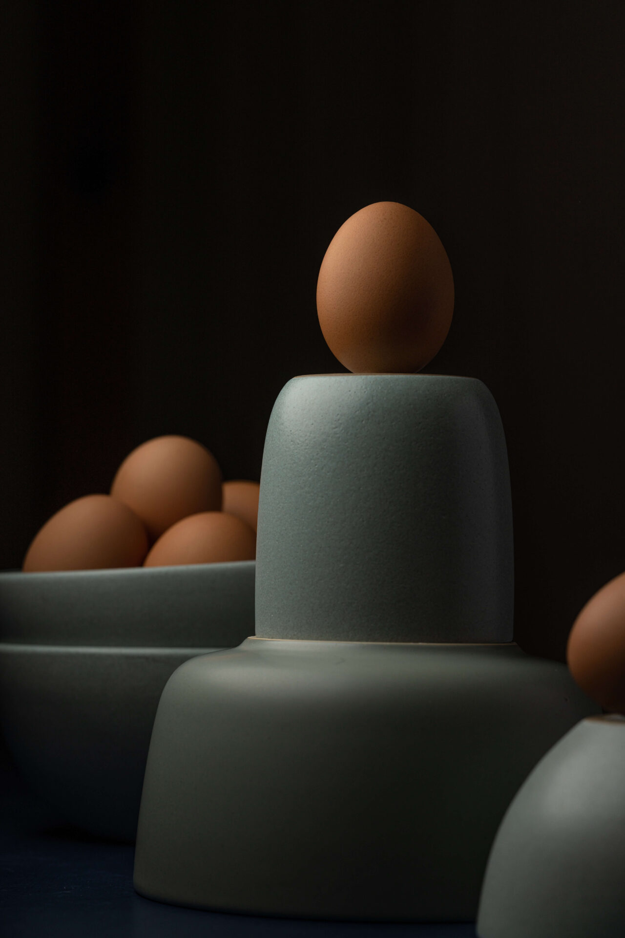 Black background with brown eggs on green ceramic dishes. Photo by skyler ewing on pexels.